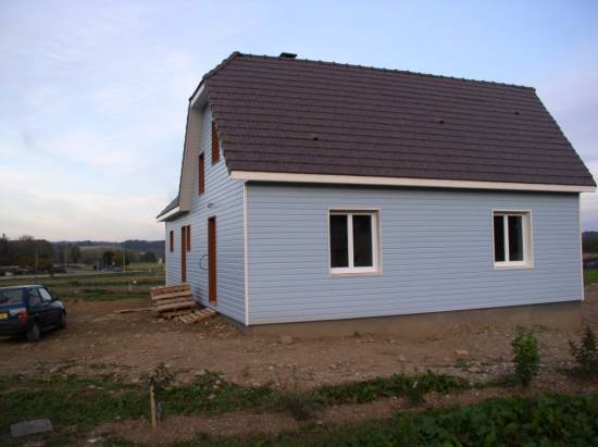 La charpente en fermettes avec comble aménageable, la pente de toit de 100% et la couverture en tuile plate noire garantissent une robustesse et une étanchéité irréprochables.dans le 64